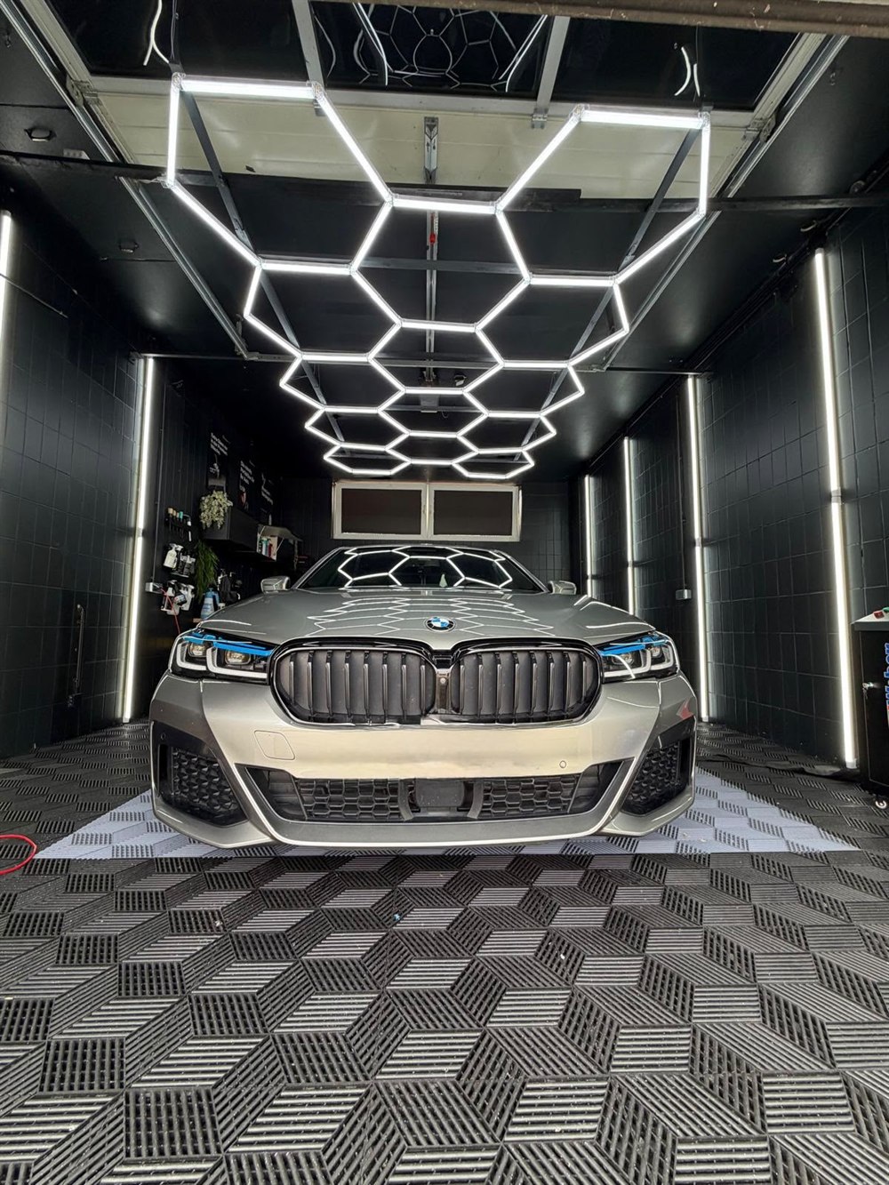 BMW 545e in Silber, Frontansicht unter dem Hexagon-Licht im Detailing-Studio in Peine