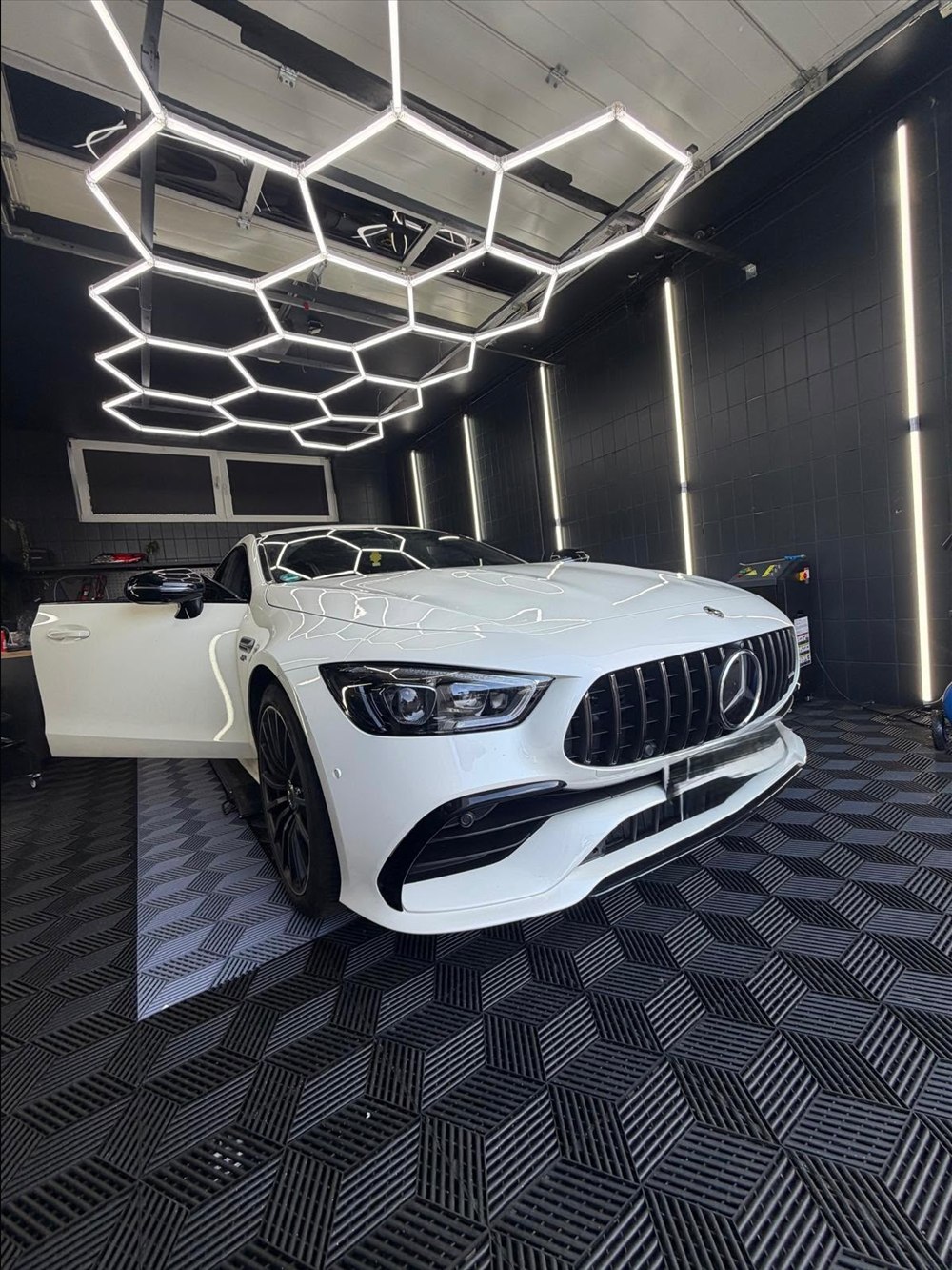 Mercedes-AMG GT in Weiß mit geöffneten Türen im Detailing-Studio