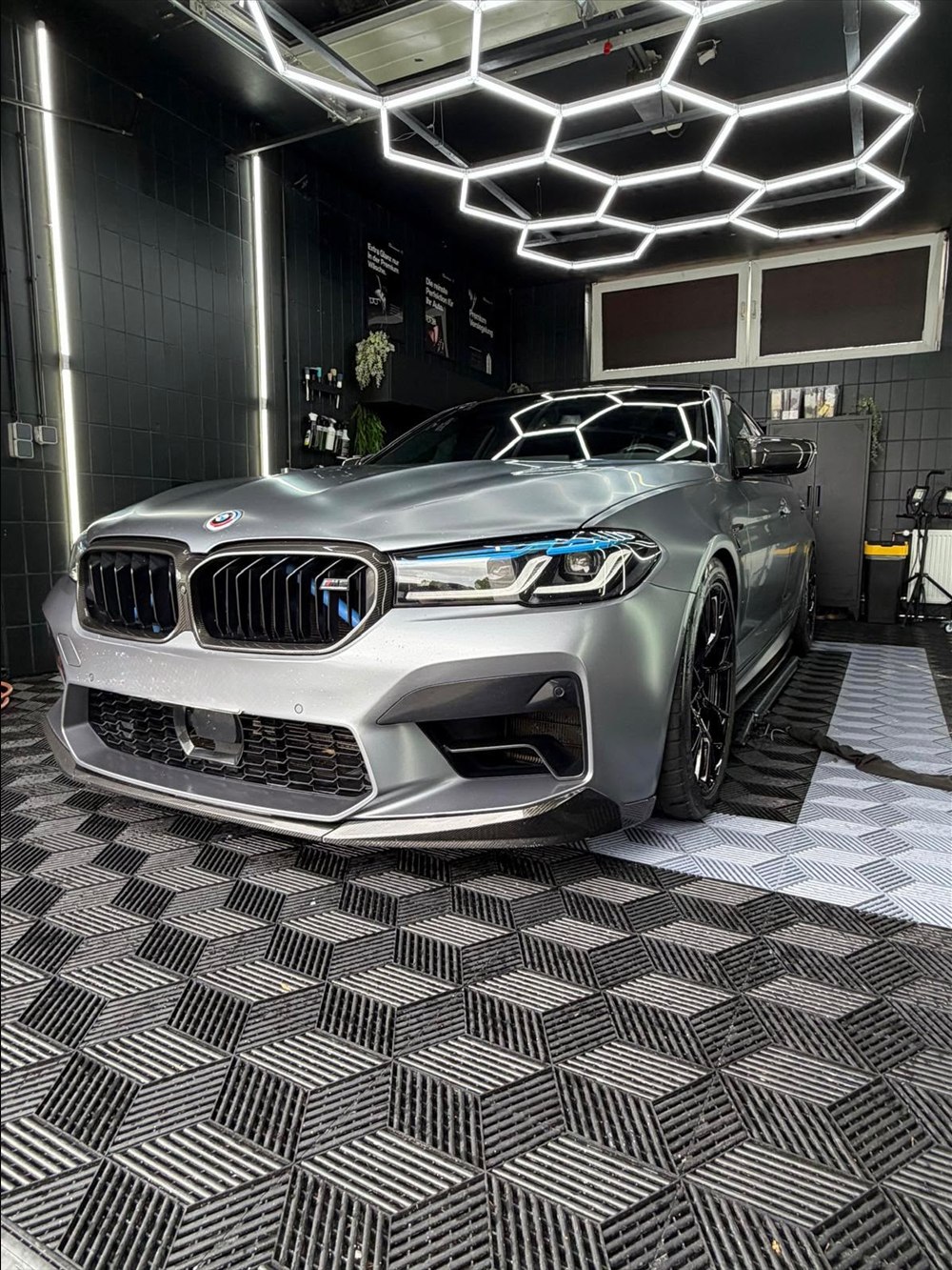 BMW M5 in Silber, seitliche Frontansicht unter dem Hexagon-Licht im Studio in Peine