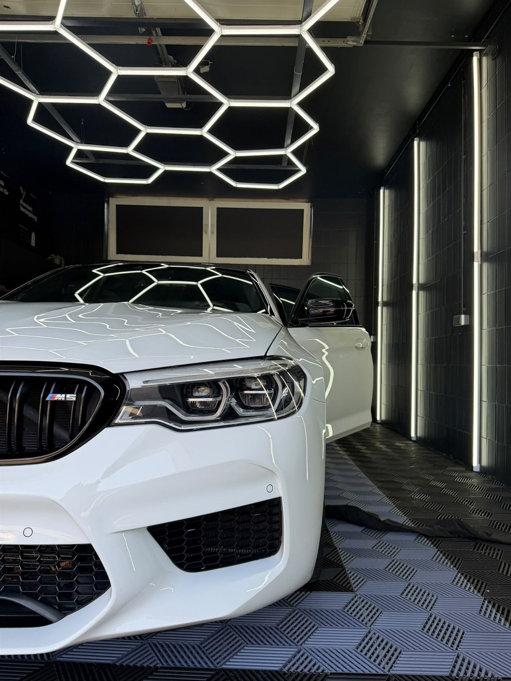 Weißer BMW M5 Competition, Front-Detail mit Scheinwerfer und M5-Niere nach der Aufbereitung