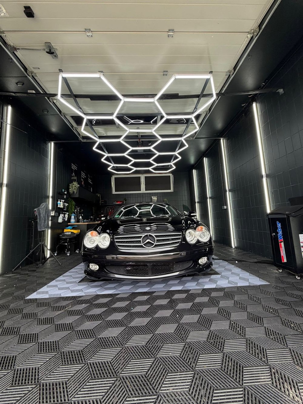 Mercedes SL 350 in Schwarz, frontale Ansicht mit Lackreflexionen im Detailing-Studio